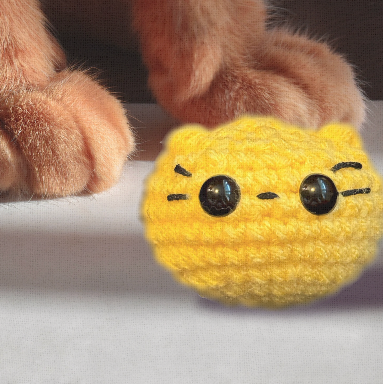 Pippa the Chonk, a 3.5 inch handmade weighted Chunkle Chunk catnip toy, shown next to a human hand for scale to demonstrate her round, substantial size