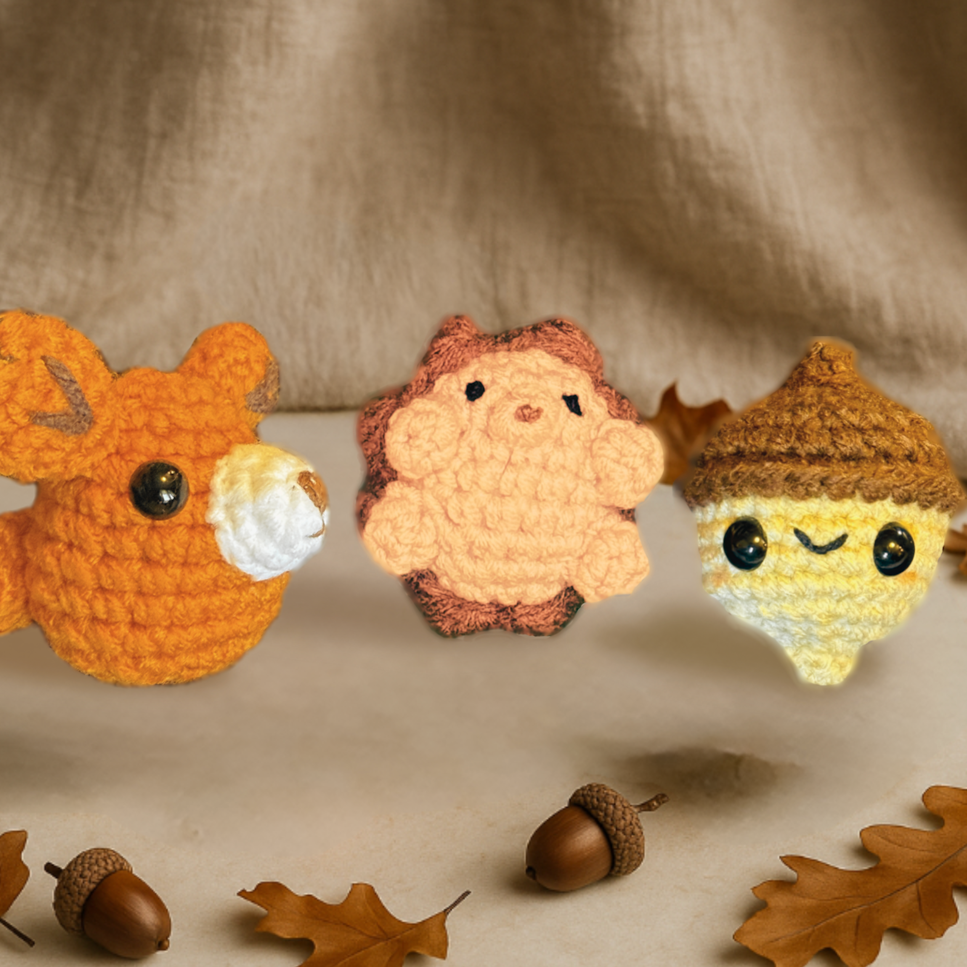 The Autumn Chunkle Collection by Minou Le-Mew, featuring Harold the Hedgehog, TJ the Fox, and Augie the Acorn catnip toys. Displayed on a brown linen background with autumn leaves and acorns, styled as a boutique seasonal set for cats and refined homes.