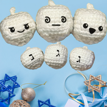 White round plush dreidel shaped toys with facial expressions on a blue background with Hanukkah decorations to represent Minou Le-Mew Chunkle catnip toy featuring Miracle Nip botanicals for cats