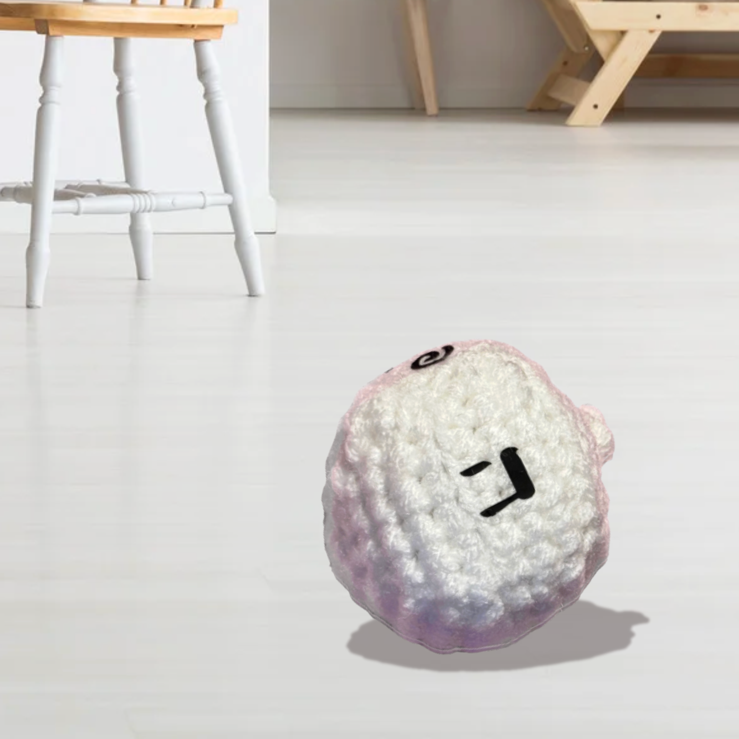 Plush dreidel-shaped cat toy with a face on a light wooden floor to represent Chunkle catnip toy infused with Miracle Nip botanicals by Minou Le-Mew