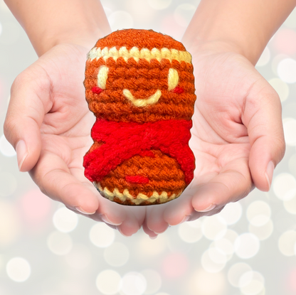 Artisan crocheted cat toy resembling a cupcake with a smiling face held in hands against a blurred light background to represent Minou Le-Mew artisan Chunkle catnip toy infused with Miracle Nip botanicals