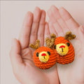 Two small crochet reindeer toys held in hands against a light pink background to represent Chunkle catnip toy infused with Miracle Nip botanicals by Minou Le-Mew