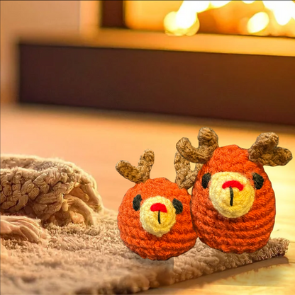 Two crochet reindeer toys on a soft surface with a warm, blurred background to represent Chunkle catnip toy infused with Miracle Nip botanicals by Minou Le-Mew