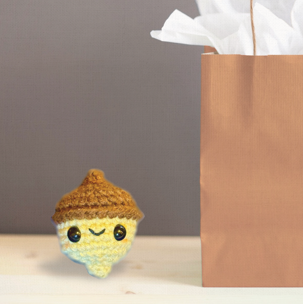 Augie the Acorn, a handmade Chunkle Puff catnip toy by Feline Grove, presented with a boutique gift bag. Designed as both a luxury collectible and refined feline plaything.