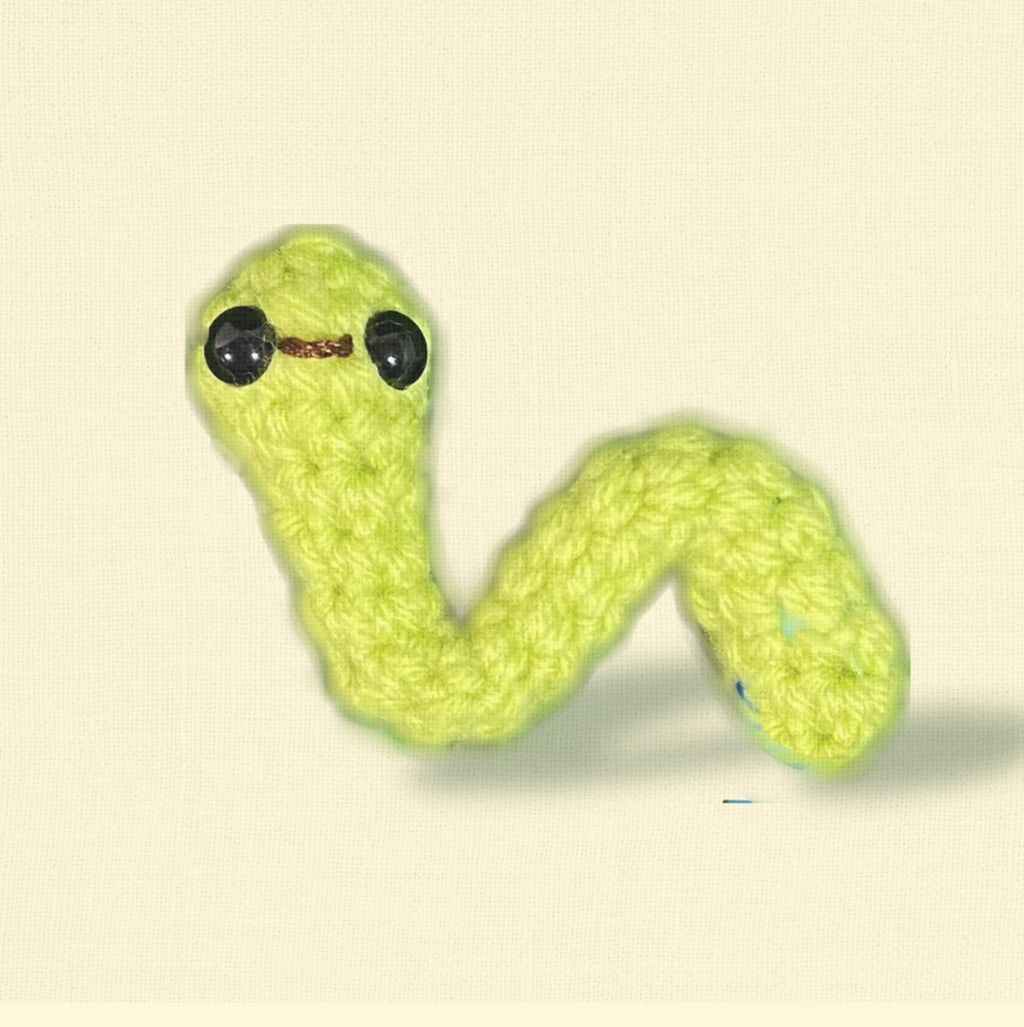 Noodle the Inchworm, a 3.5 inch handmade Chunkle Puff catnip toy by Feline Grove, shown alone on a neutral background. An elongated woven form highlights boutique craftsmanship and luxury design.