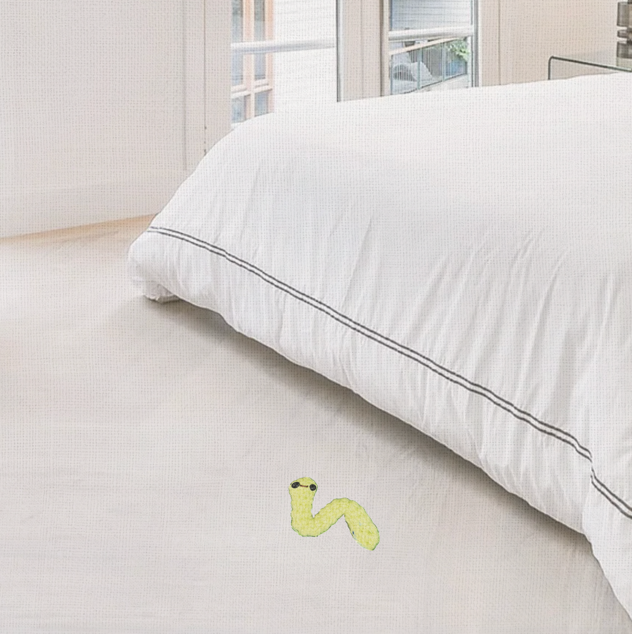 Lifestyle photo of Noodle the Inchworm, a handmade Chunkle Puff catnip toy by Feline Grove. Shown in a refined interior with linen backdrop, presenting him as a boutique play object for elegant homes.