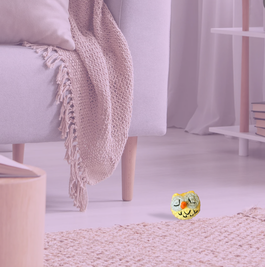 Yolk the Owl, a handmade Chunkle Puff catnip toy measuring approx. 2 inches round, shown beside a familiar object for scale. Woven owl-inspired form highlights petite size and luxury craftsmanship.