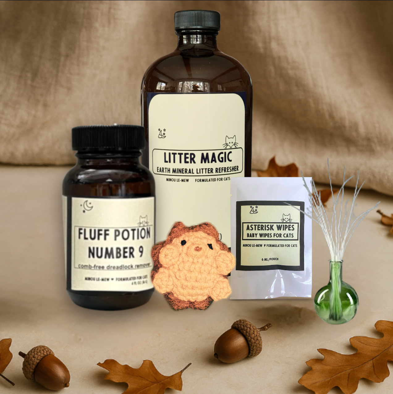 luff Potion Number 9, a 4 fl oz amber glass bottle , presented with litter magic, Harold the Chunkle Puff, a single Asterisk Wipe, and a whisker vase as part of Minou Le-Mew’s Care Collection of companion cat essentials.