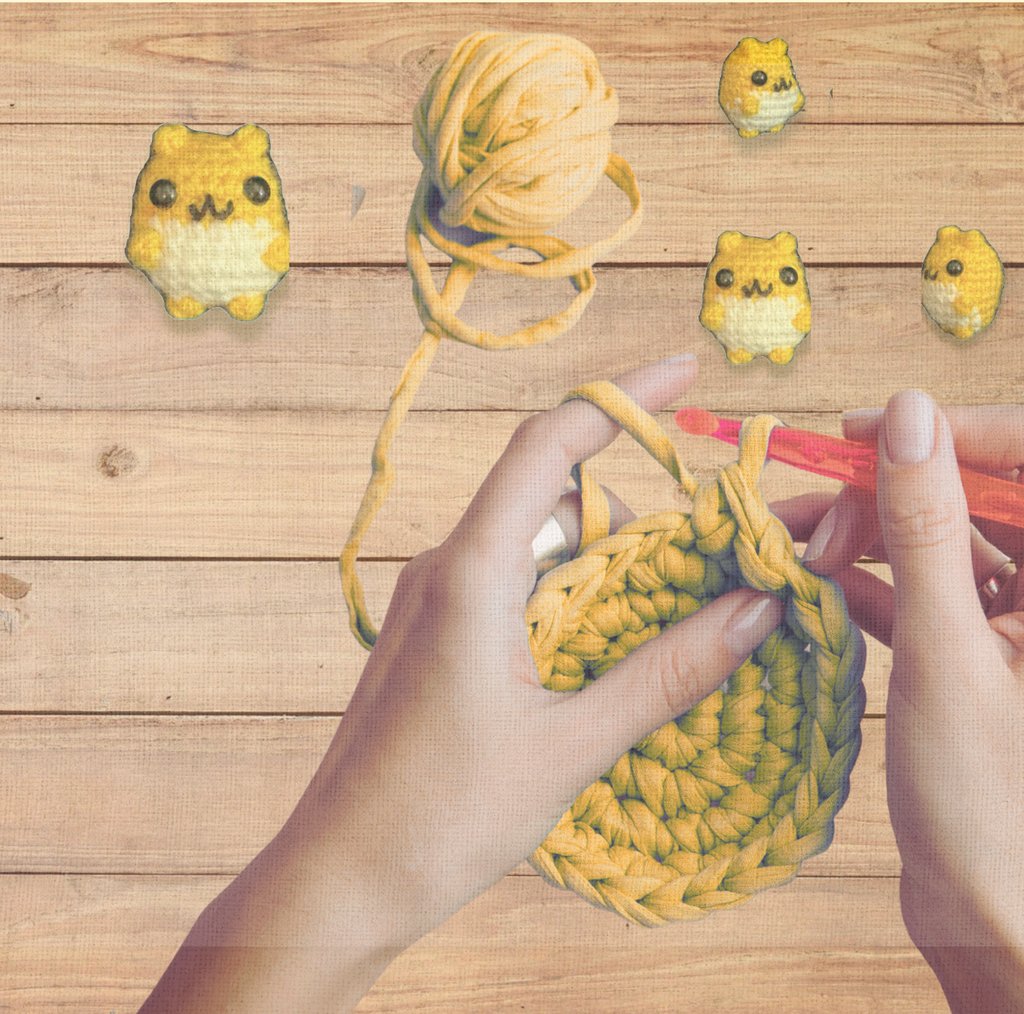 Hands crocheting a yellow magic ring with the Cat Toy Crochet Kit, finished toy in the background on blonde wood. A process detail that shows ease of use.