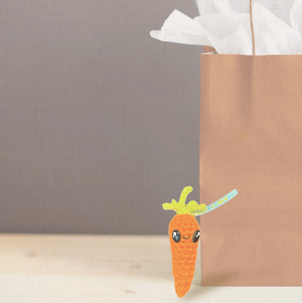Lulu the Carrot, a handmade Chunkle Puff catnip toy by Minou Le-Mew, shown with a boutique gift bag. Presented as a luxury collectible piece for refined gifting.