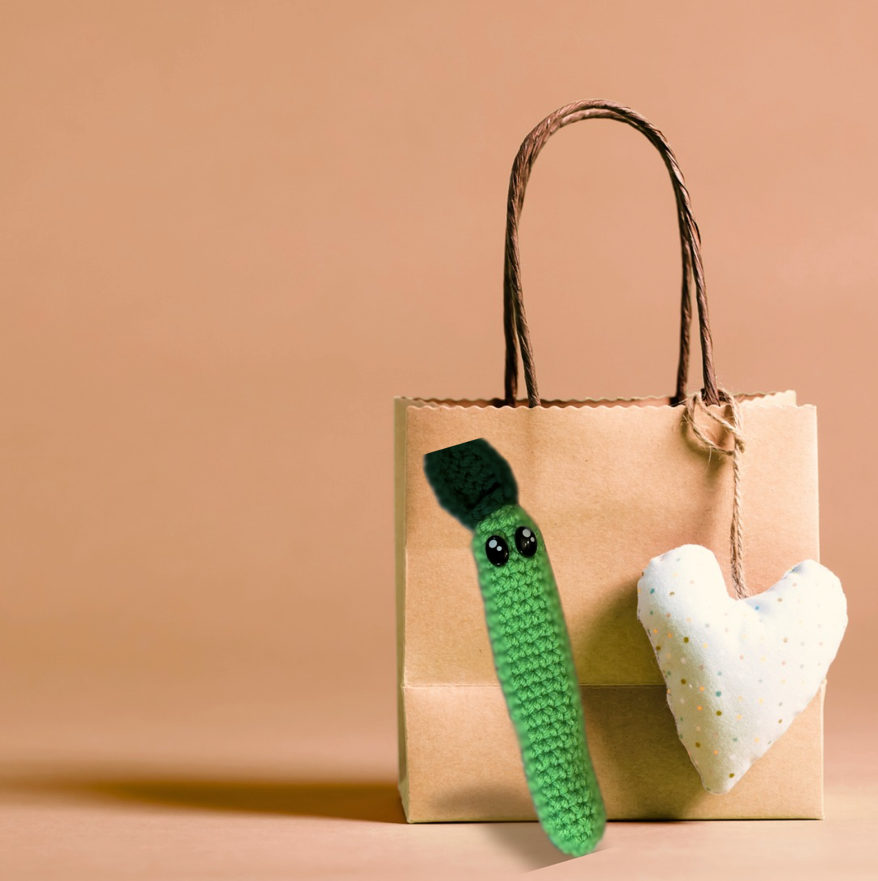 Noodle the Inchworm, a handmade Chunkle Puff catnip toy by Minou Le-Mew, presented with a boutique gift bag. The elongated design is styled as a luxury collectible piece.